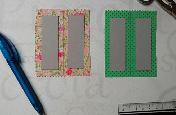 Each rectangle of cardboard is placed on top of a piece of fabric larger than this one. Two rectangles with floral print and the other two green with polka dots.