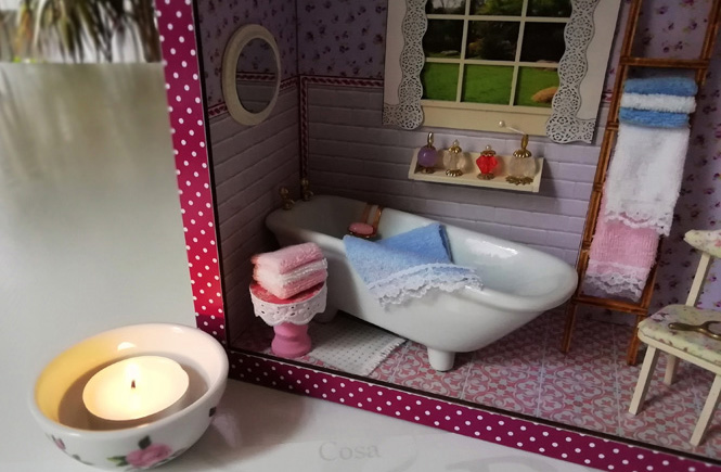 Ambiente de un baño en miniatura con una vela en el exterior.