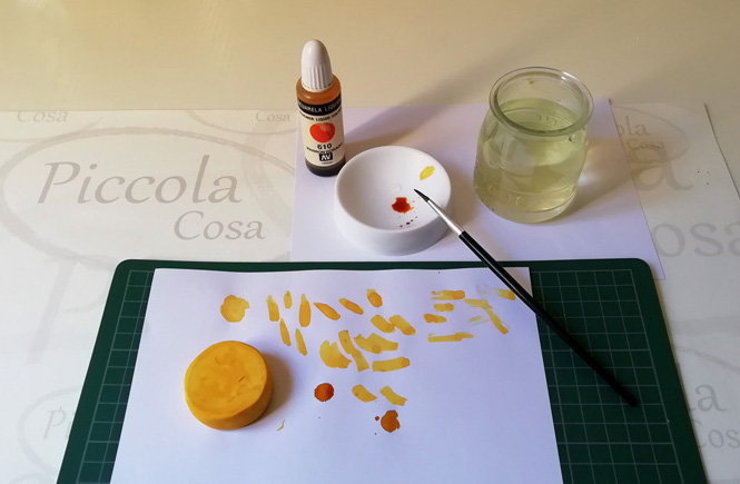 Plastilina a forma circolare. Con un pennello diamo colore per farlo sembrare una torta meno la parte superiore.