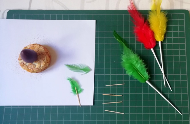 Plumas muy pequeñas con un palito de palillo pegado por detrás