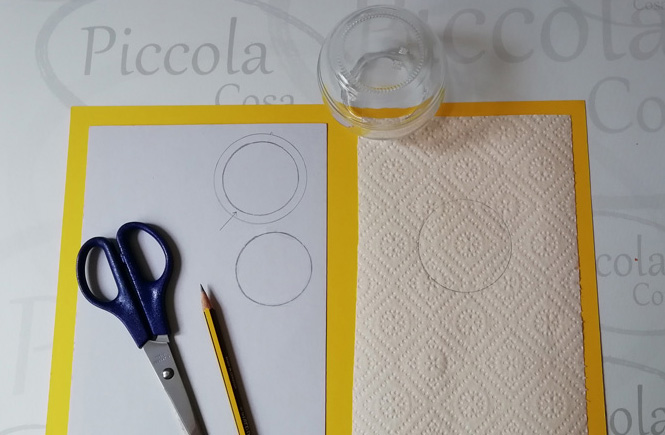 Two circles drawn on a cardboard; one larger than the other. The largest is used as a template to make a doilies that is made with kitchen paper.