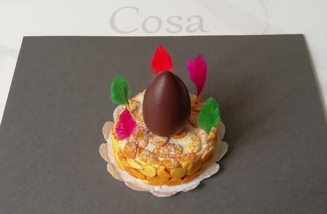 The cake with the chocolate egg and the feathers is glued on top of the doilies.